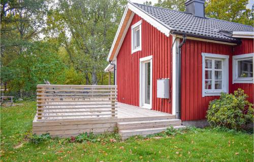 una casa rossa con una terrazza in legno nel cortile di Awesome Home In Lckeby With Kitchen 