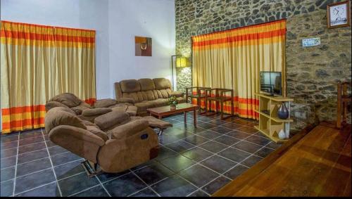 ein großes Wohnzimmer mit Sofas und einem TV in der Unterkunft Reef Bungalow Private Villa, 4 bedrooms in Bopitiya
