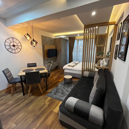 a living room with a couch and a dining room at President Kop - Silver Ice Apartment in Kopaonik
