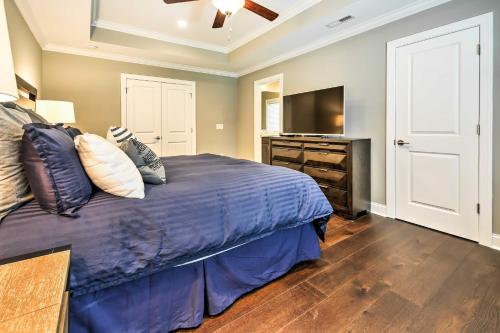 a bedroom with a bed and a flat screen tv at Downtown Townhome Walk to Dine and Shop on Broad St in Southern Pines