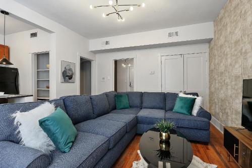 a living room with a blue couch with green pillows at St Charles-Mardi Gras 6BD Home in New Orleans