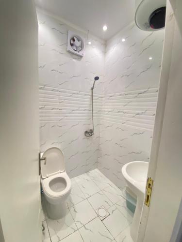 a white bathroom with a toilet and a sink at شقة بدخول ذاتي in Riyadh