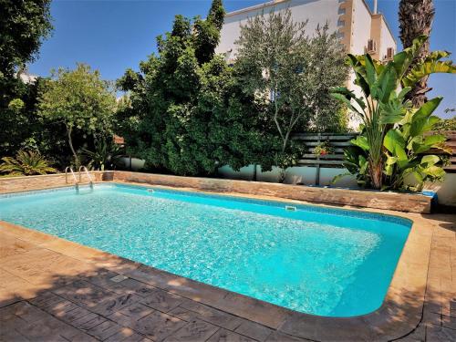 a swimming pool in a yard with trees at Mosaic villa by the sea in Protaras