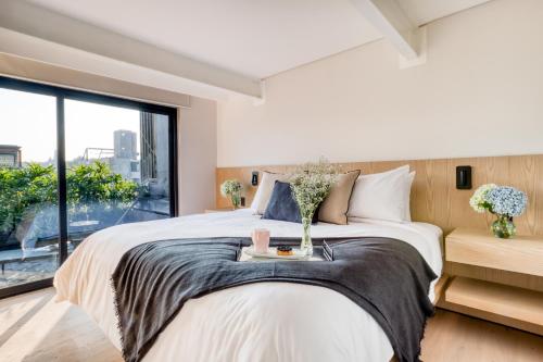 a bedroom with a large bed and a large window at ULIV Edgar Allan Poe in Mexico City