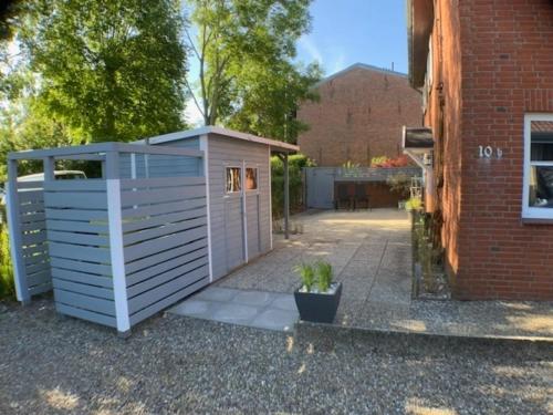 a small white shed next to a brick building at Stadtquartier 1 EG in Bredstedt