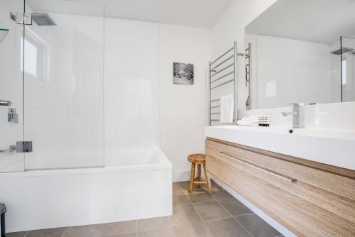 uma casa de banho branca com uma banheira e um lavatório em Stillwater Chalet B Crackenback em Crackenback