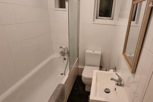 ein Badezimmer mit einer Badewanne, einem WC und einem Waschbecken in der Unterkunft Cosy 3BR Hastings House in Maidstone Kent in Kent