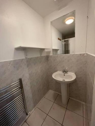 y baño con lavabo y espejo. en lovely 4 bedroom 2 bathroom home en Londres