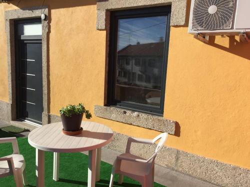 a table and chairs next to a building with a window at Serrano T1 centro da cidade in Guarda