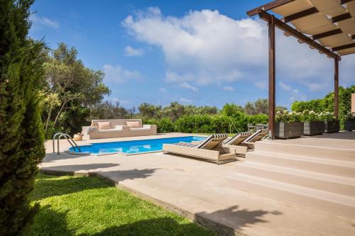 einen Pool mit Liegestühlen und eine Terrasse in der Unterkunft Sotiris villas in Svoronata