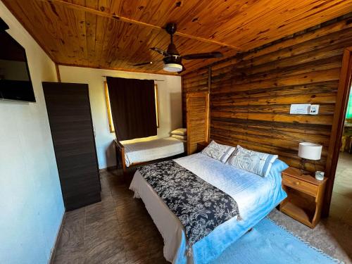 a bedroom with a bed and a wooden wall at el PARAISO in Villa Anizacate