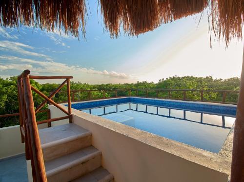 a swimming pool on the balcony of a house at Naajal Tulum Boutique Hotel - Magic & Jungle in Tulum