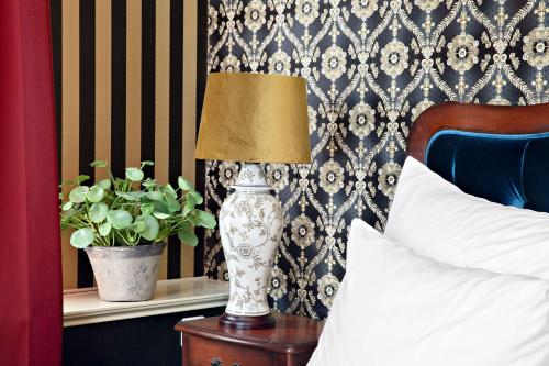 a lamp sitting on a table next to a bed at Best Western Hotel Gamla Teatern in Östersund