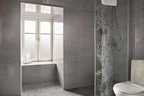 ein Bad mit einer Dusche, einem WC und einem Fenster in der Unterkunft Best Western Hotel Gamla Teatern in Östersund