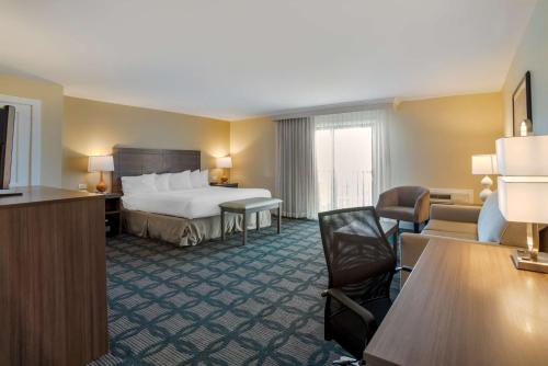 een hotelkamer met een bed, een bureau en stoelen bij Best Western Plus Ocean City in Ocean City