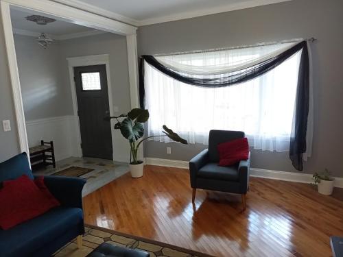 a living room with two chairs and a window at Cozy Updated 3-BR apartment near Peace Bridge in Buffalo
