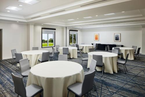 a conference room with tables and chairs in a room at Holiday Inn Express Hotel & Suites Port St. Lucie West by IHG in Port Saint Lucie