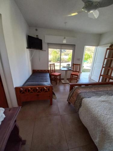 a room with two beds and a table and chairs at Hostería Los Naranjos in Potrero de los Funes