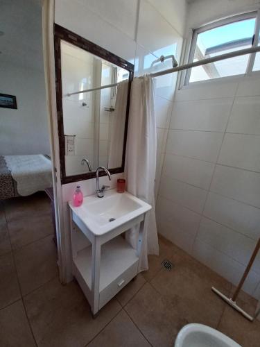 y baño con lavabo y ducha con espejo. en Hostería Los Naranjos en Potrero de los Funes