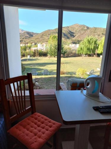 a table and a chair in front of a window at Hostería Los Naranjos in Potrero de los Funes