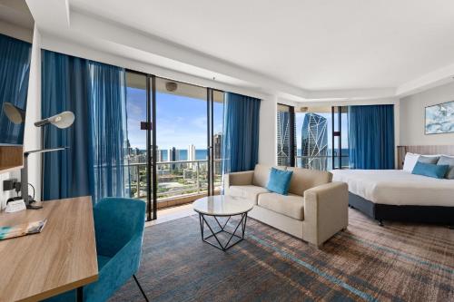 una camera d'albergo con letto e divano di Crowne Plaza Surfers Paradise, an IHG Hotel a Gold Coast
