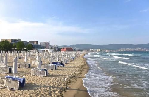 a beach with lounge chairs and the ocean at PARADISO 'В' 408 Private Studio Nessebar in Nesebar
