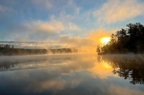 a misty morning on a lake with the sun setting at Massachusetts Lake House with Dock - Pets Welcome! in New Marlborough
