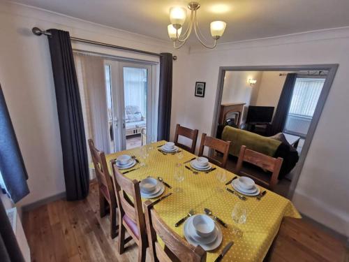 a dining room with a table with a yellow table cloth at Twyngaer, a spacious 3 bedroom bungalow sleeps 6 in Knighton