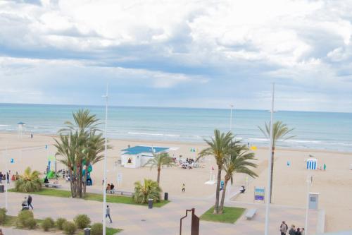 vistas a una playa con palmeras y al océano en 201 I Posada del Mar I Encantador hostel en la playa de Gandia, en Los Mártires