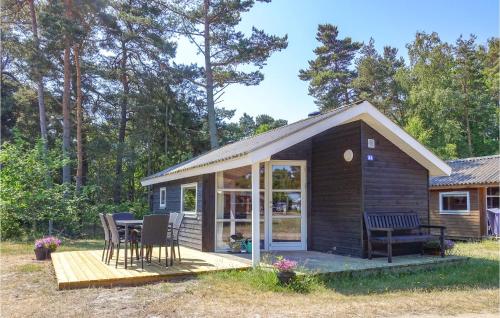 a small cabin with a table and chairs on a deck at Gorgeous Home In Nexø With Kitchen in Neksø