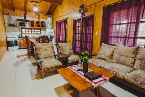 ein Wohnzimmer mit einem Sofa, Stühlen und einem Tisch in der Unterkunft Cabañas Riberas del Paraná in Puerto Iguazú