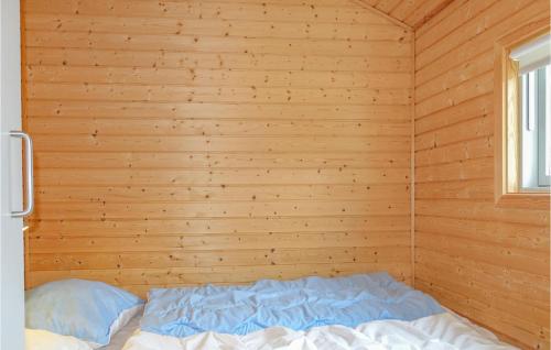 a bed in a room with a wooden wall at Gorgeous Home In Nex With Kitchen in Neksø