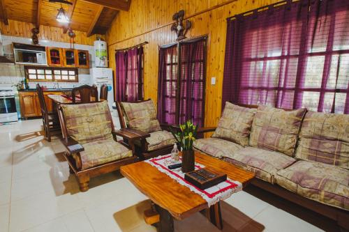 ein Wohnzimmer mit Sofas und einem Couchtisch in der Unterkunft Cabañas Riberas del Paraná in Puerto Iguazú