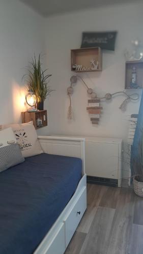 una camera da letto con un letto con lenzuola blu e una pianta di Strandkorb 60 - kleine günstige FeWo an der Ostsee zwischen Dahme und Heiligenhafen a Heringsdorf