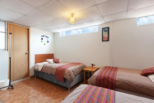 a hotel room with two beds and a window at Magic Cusco in Cusco