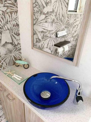 a bathroom with a blue sink and a mirror at Pier39 Uchiumi Cozy house located in front of the sea and harbor! in Miyazaki