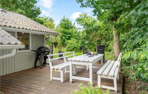 a wooden deck with a picnic table and two chairs at 3 Bedroom Cozy Home In Nibe in Nibe