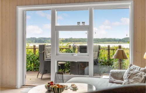 a living room with a sliding glass door with a view of a patio at 3 Bedroom Cozy Home In Nibe in Nibe