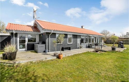a small house with a wooden deck in a yard at Beautiful Home In Otterup With Kitchen in Otterup