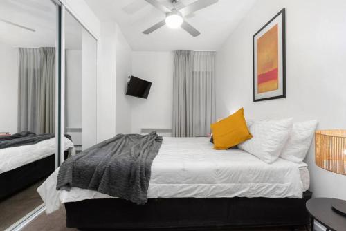 a bedroom with a bed with a yellow pillow at 108 Astral Apartments in Melbourne