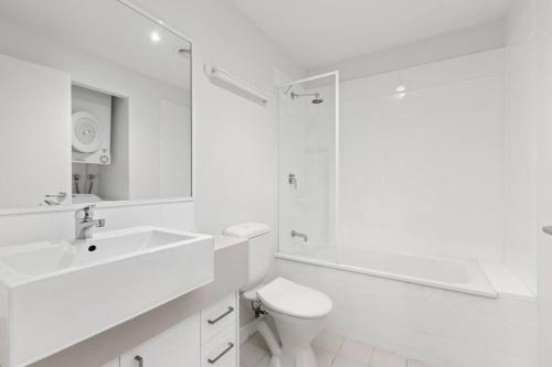 La salle de bains blanche est pourvue d'un lavabo et d'une douche. dans l'établissement 108 Astral Apartments, à Melbourne