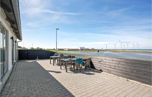 a patio with tables and chairs next to a body of water at Gorgeous Home In Glesborg With Wifi in Glesborg