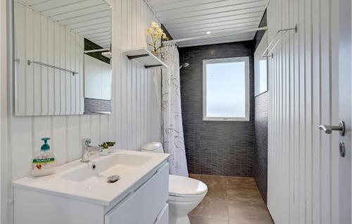 La salle de bains est pourvue d'un lavabo blanc et de toilettes. dans l'établissement 3 Bedroom Awesome Home In Hejls, à Hejls
