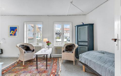奧本羅的住宿－Amazing Apartment In Aabenraa With Wifi，一间卧室配有一张床、两把椅子和一张桌子