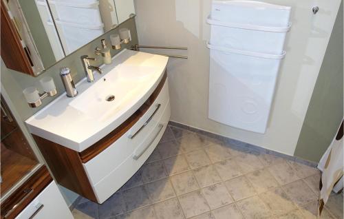 a bathroom with a sink and a washer and dryer at 1 Bedroom Stunning Home In Gudhjem in Gudhjem