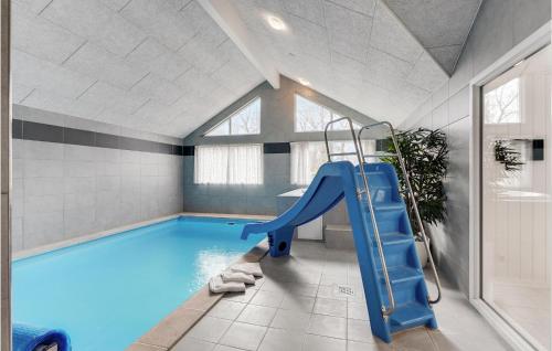 a swimming pool with a blue slide in a room at Stunning Home In Væggerløse With Sauna in Marielyst