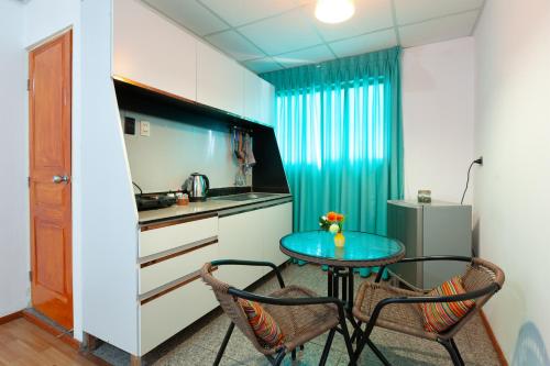 Una pequeña cocina con una mesa y dos sillas. en Magic Cusco, en Cusco