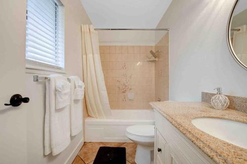 y baño con lavabo, aseo y bañera. en Resort Style 4BR House with Pool Min from Strip en Las Vegas