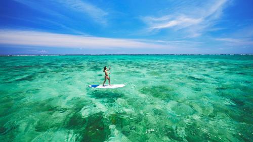 a person on a surfboard in the ocean at ANA InterContinental Ishigaki Resort by IHG in Ishigaki Island