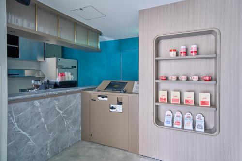 a kitchen with a counter and a refrigerator with milk bottles at FAV TOKYO Nishinippori in Tokyo